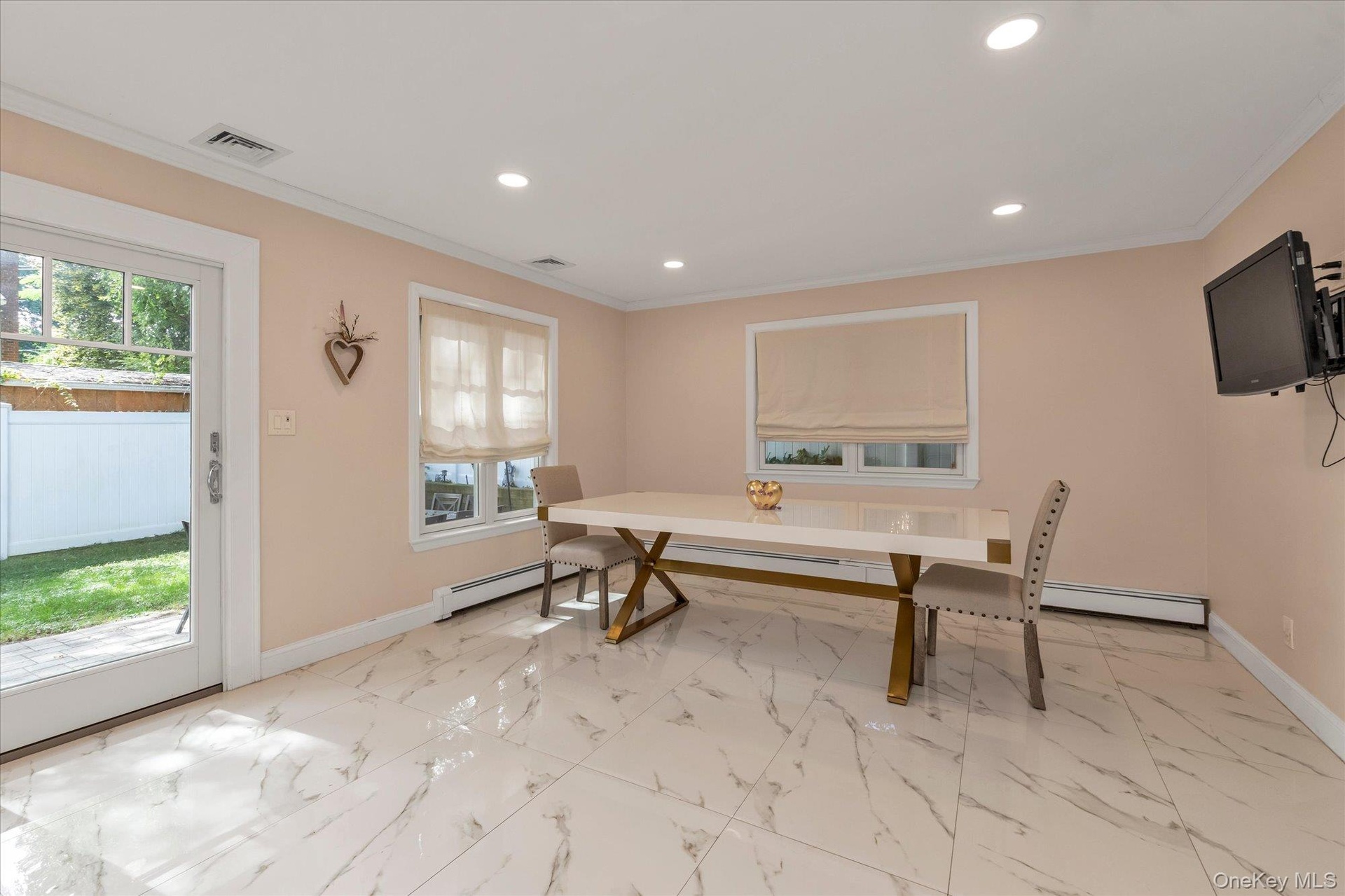 Ideal for entertaining with an open floor plan, crown molding, recessed lighting, and sliding glass doors to patio.