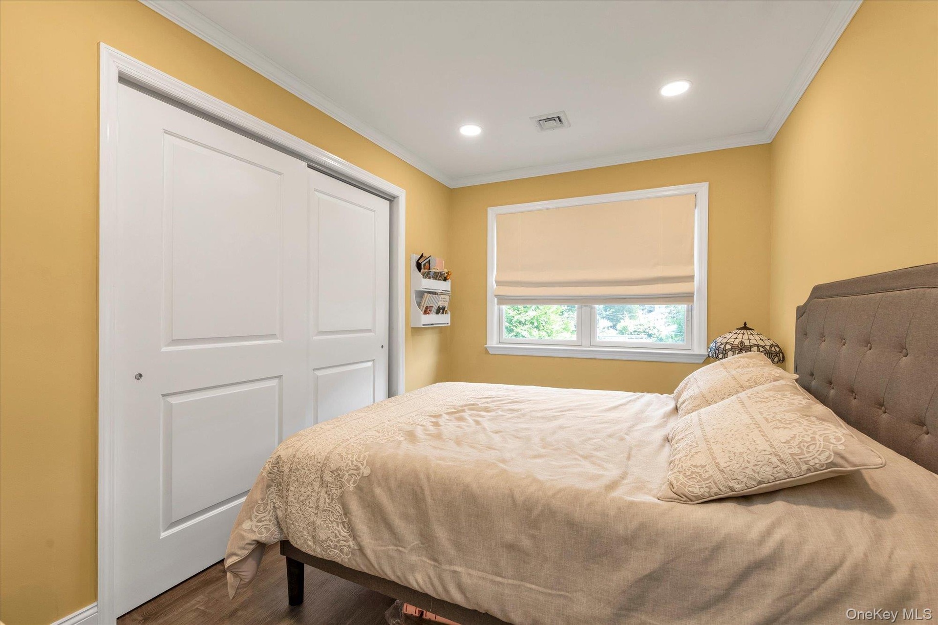 Bedroom #2 Recessed ceiling lighting, crown molding, white trim, sliding panel closet doors, and wood-finish flooring