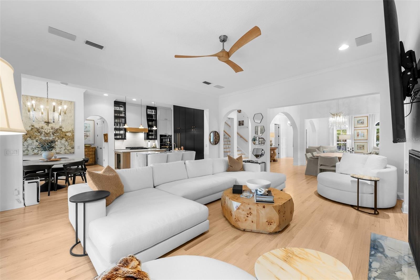 Open family room with ceiling fan, French doors to the lanai, and direct connection to the kitchen.