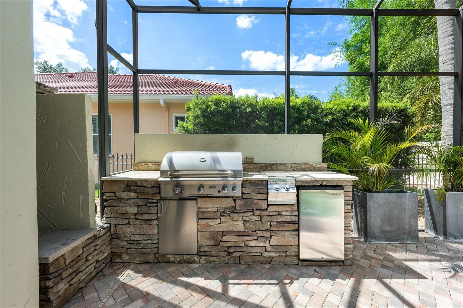 Outdoor kitchen — Stacked-stone outdoor kitchen with built-in gas grill and refrigerator.