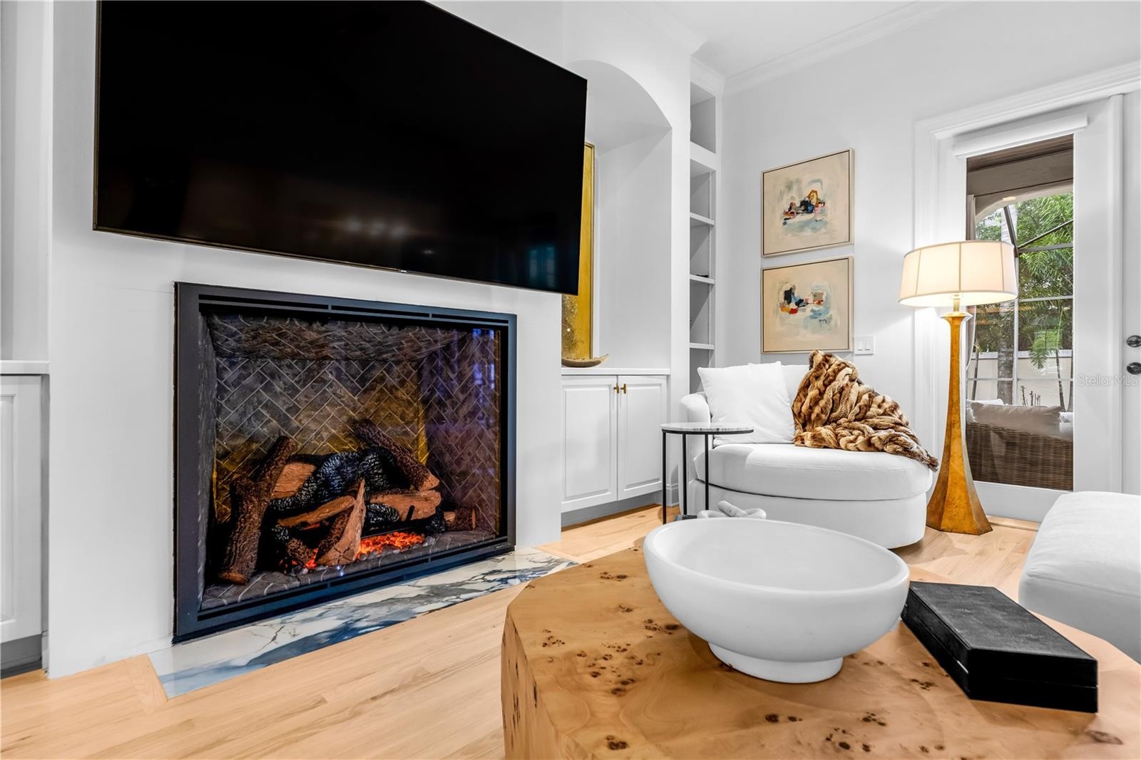 Fireplace with mounted TV and flanking built-in shelving.