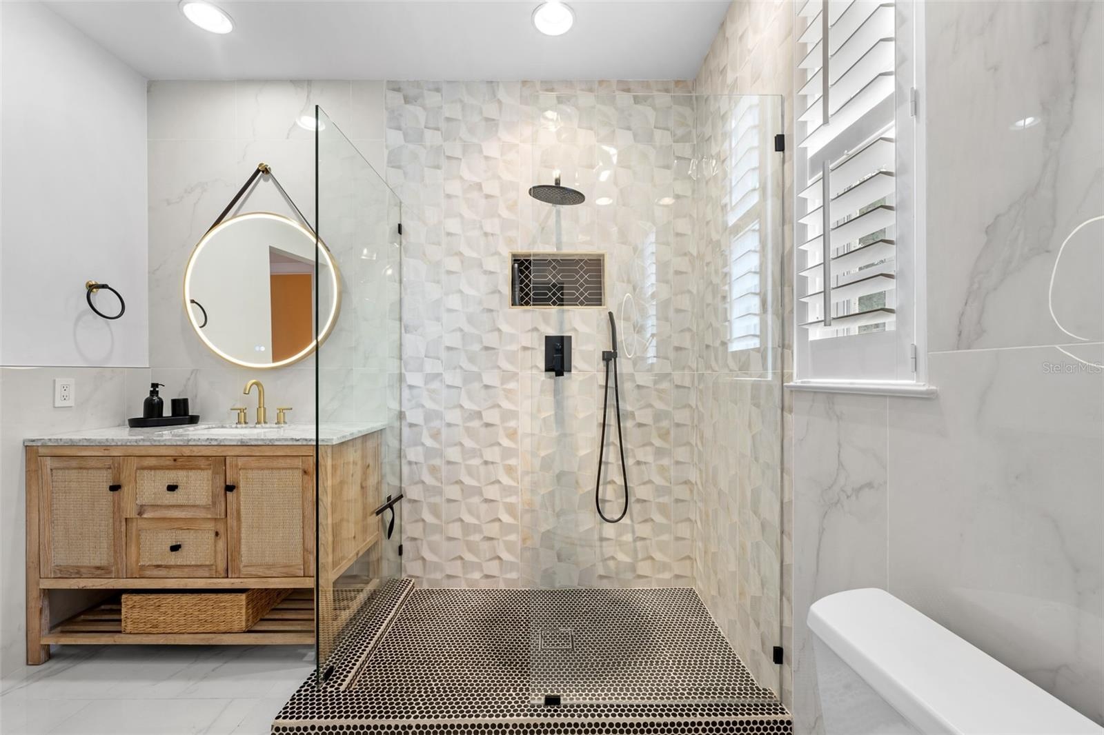 Second Bathroom (upstairs) - Glass-enclosed shower with three-dimensional tile, wall niche, and window with plantation shutters.