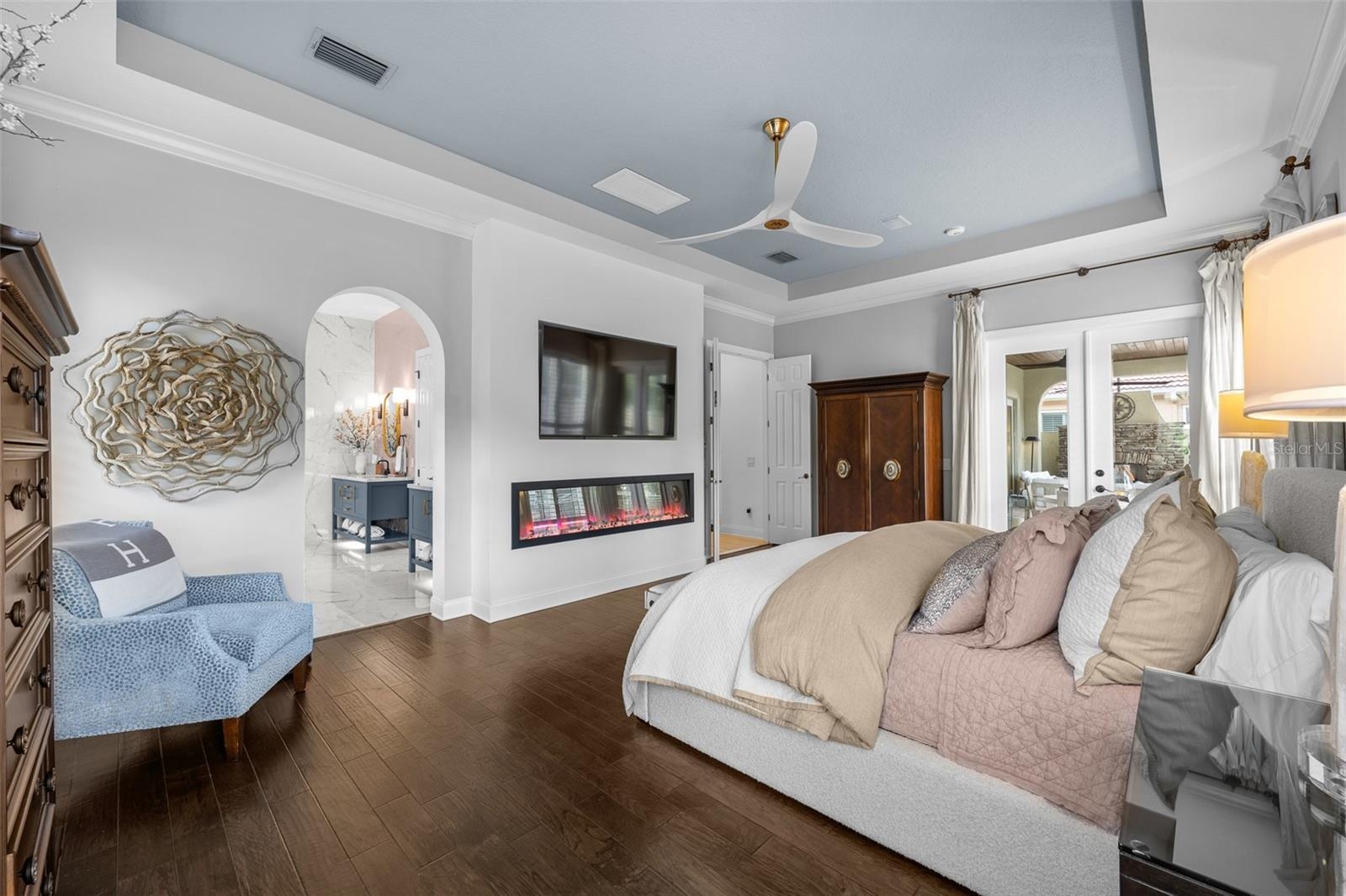 French doors, arched window, and linear electric fireplace.