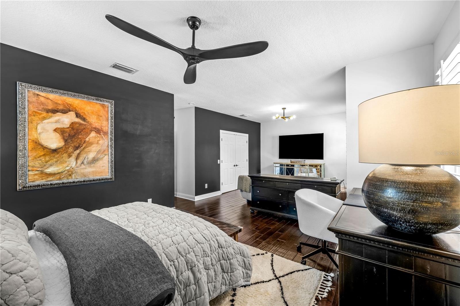 3rd Bedroom - Dark accent wall, ceiling fan, and window with plantation shutters.