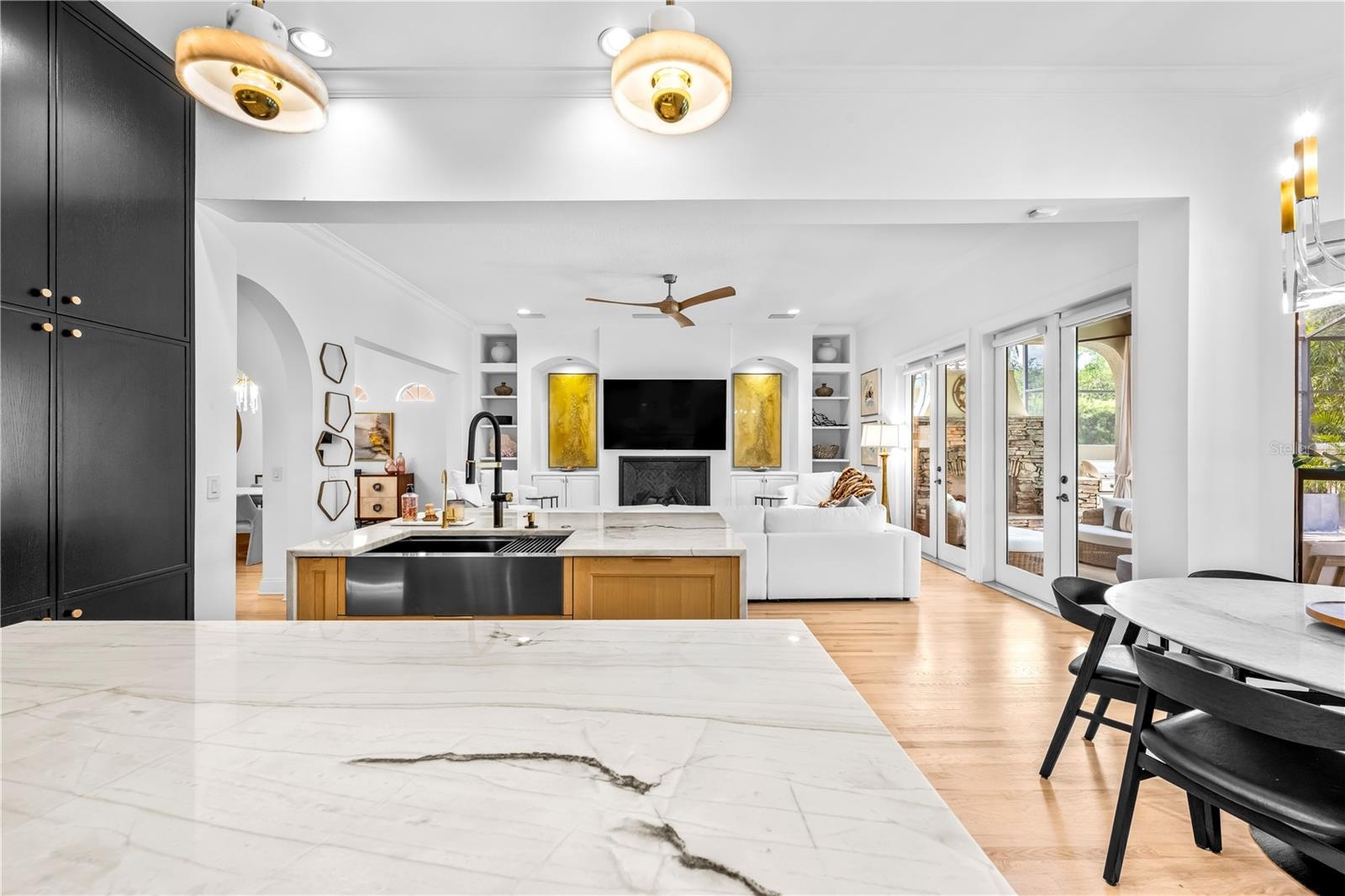 Veined stone island countertop with view to the family room and French doors beyond.
