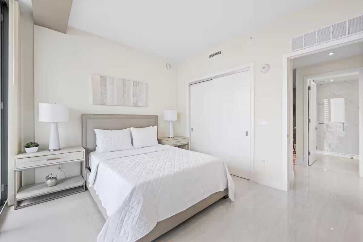 Recessed lighting, wood-finish flooring, sliding closet door, and a full bathroom with a tiled shower