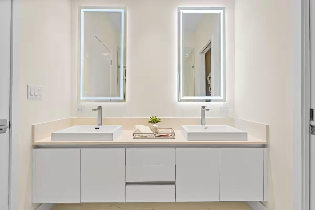 Dual vanity with white flat-panel cabinetry and integrated rectangular sinks