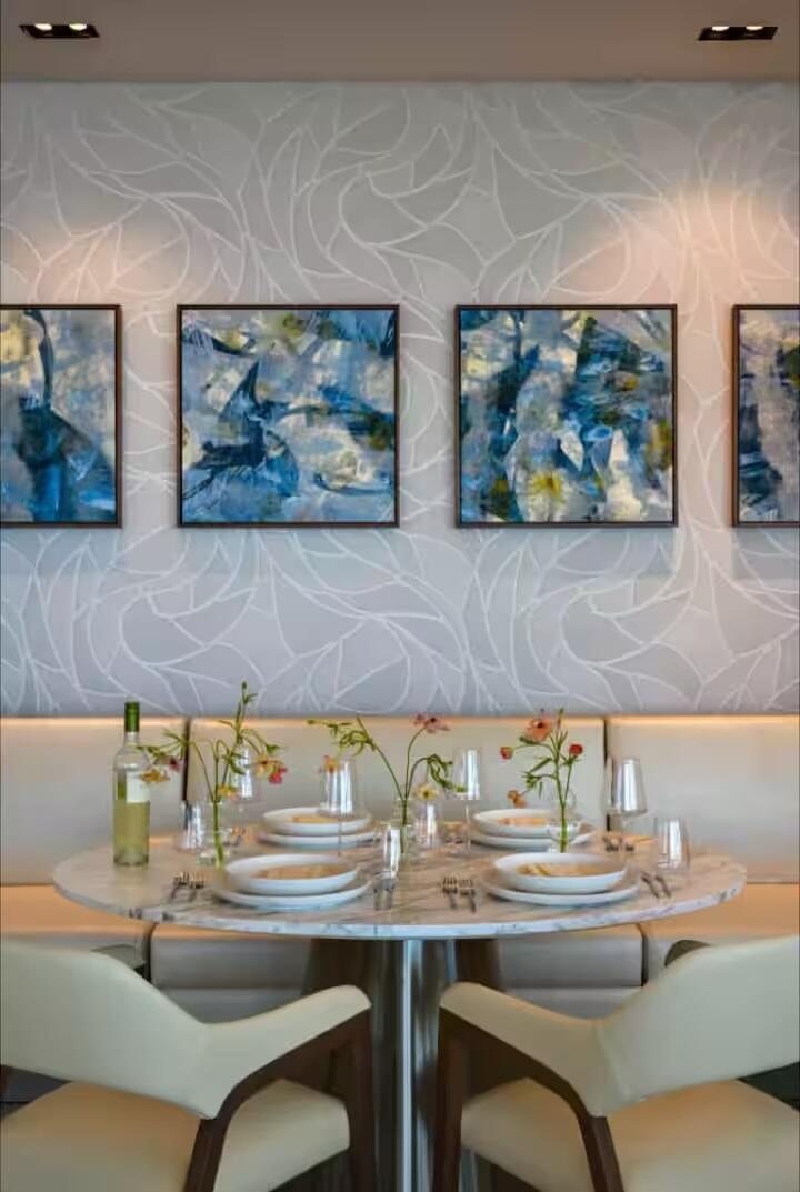 Built-in banquet seating, round pedestal table, and recessed ceiling lighting