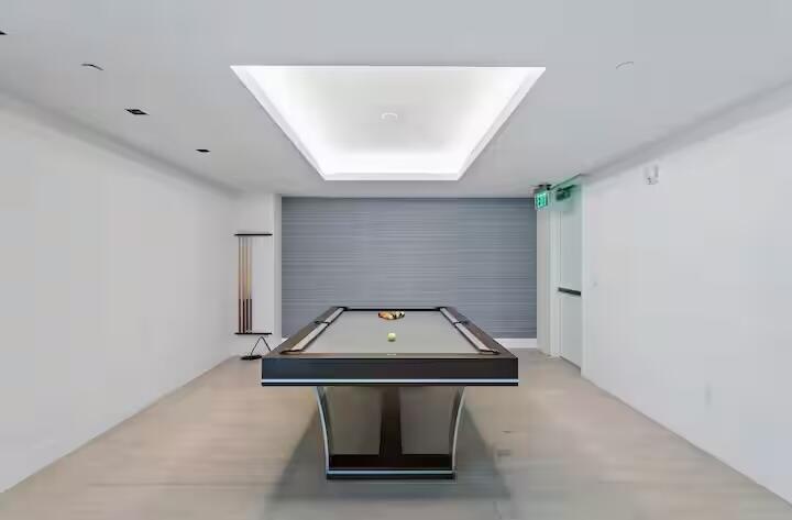 Recreation room featuring a contemporary pool table, recessed lighting, and a tray ceiling with integrated illumination