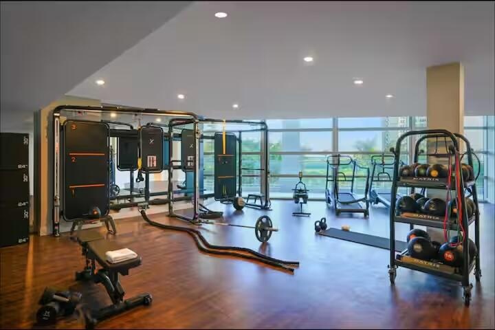 Dedicated fitness area featuring wood-finish flooring, recessed lighting, and expansive windows