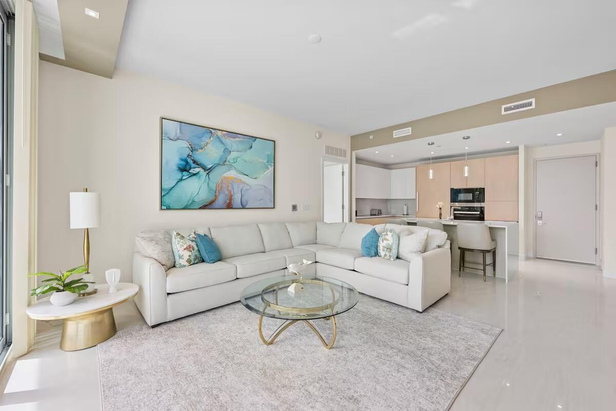 Recessed lighting, wood-finish flooring, a kitchen island with built-in appliances, and a wall of glass doors