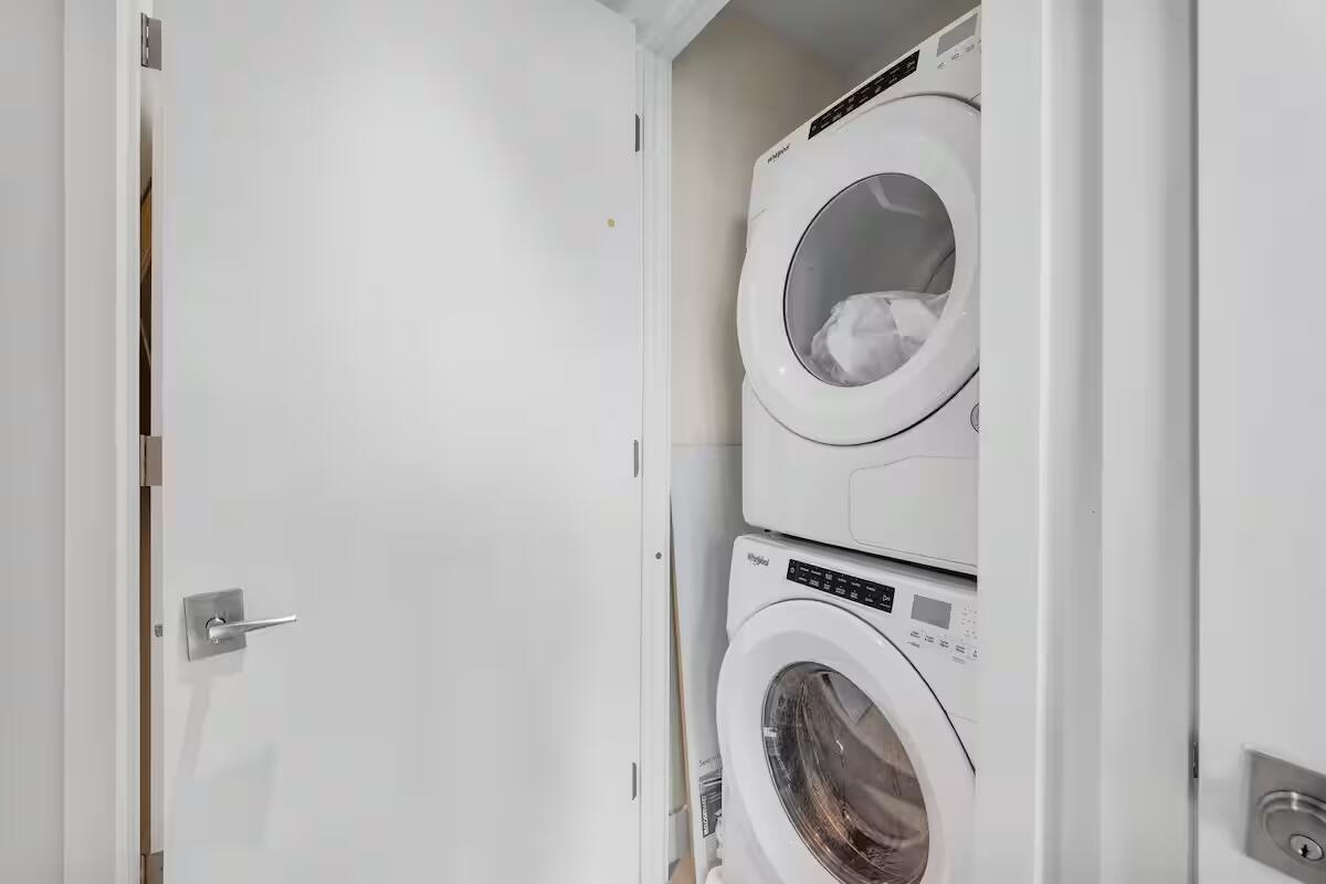 Stacked washer and dryer units within an interior utility closet