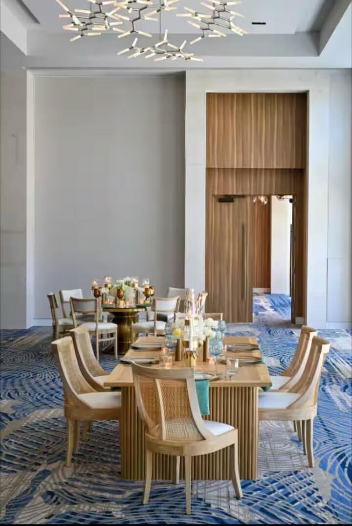 High ceilings with a contemporary chandelier, wood-paneled walls, and a recessed doorway