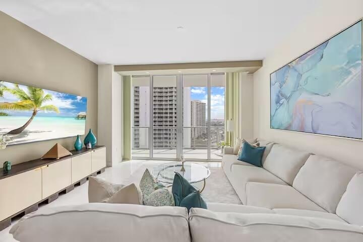 Expansive living space featuring a built-in media console, large format tile flooring, and a sliding glass door to a balcony