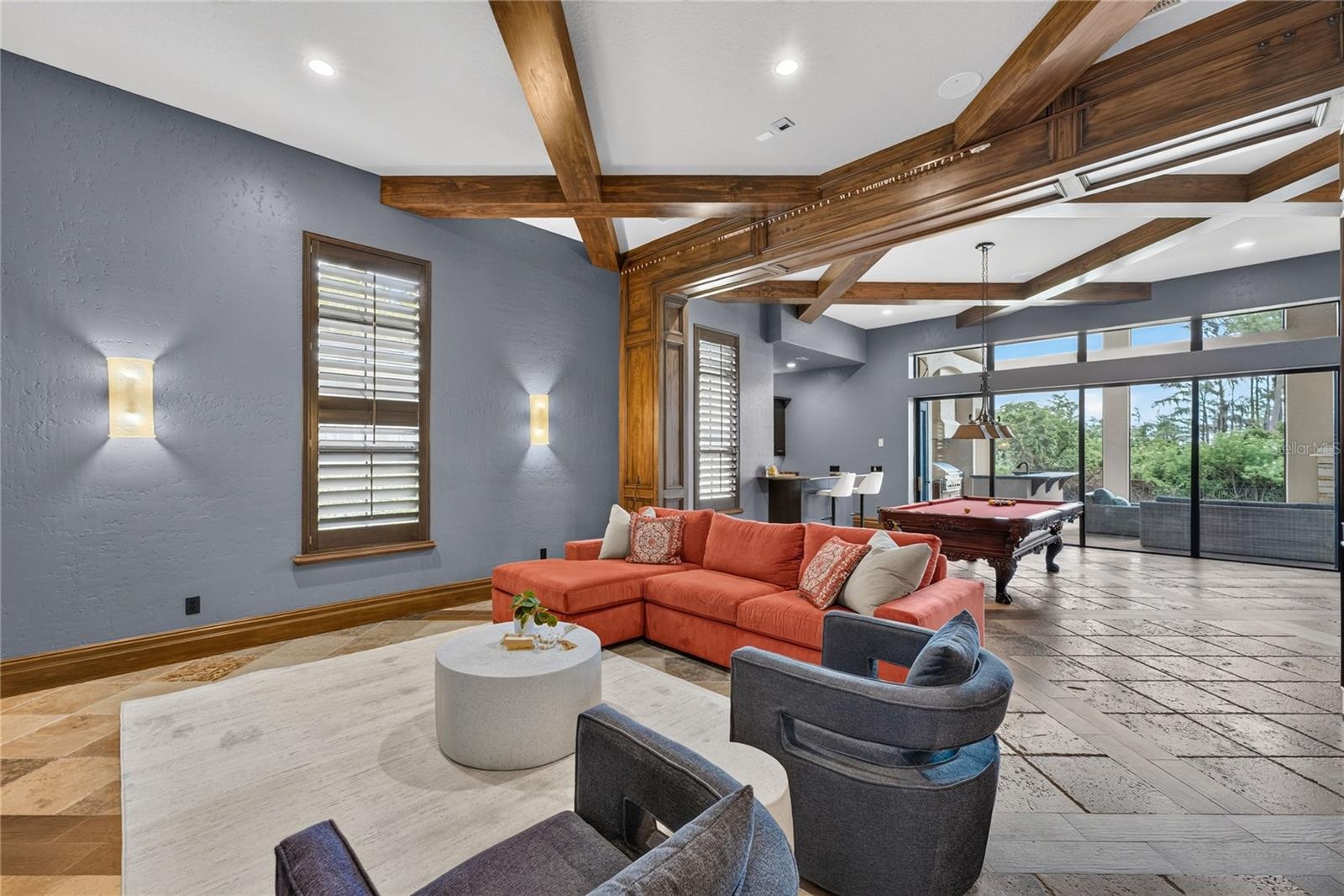 Game/Media room located off the family room. Beyond the pool table a wall of sliders pocket to open the screened lanai to this area for seamless outdo