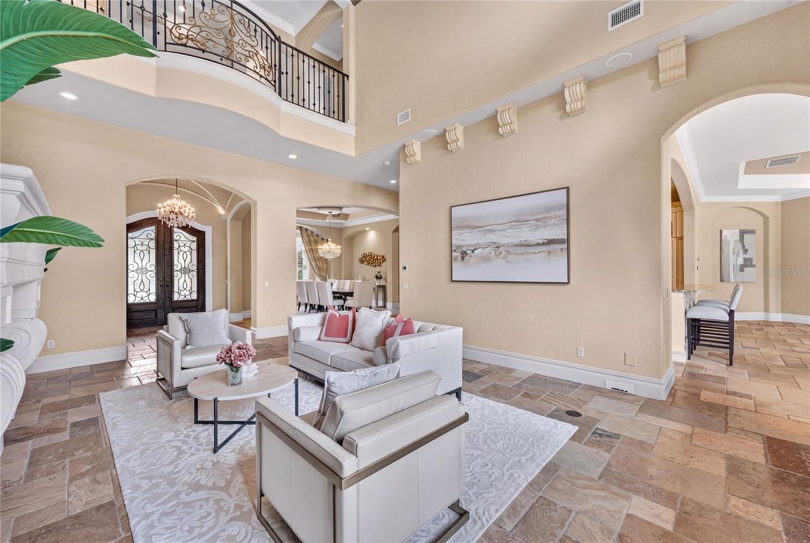 The formal living opens to casual living with access via the arched entry seen to the right as well as through the dining/bar area.