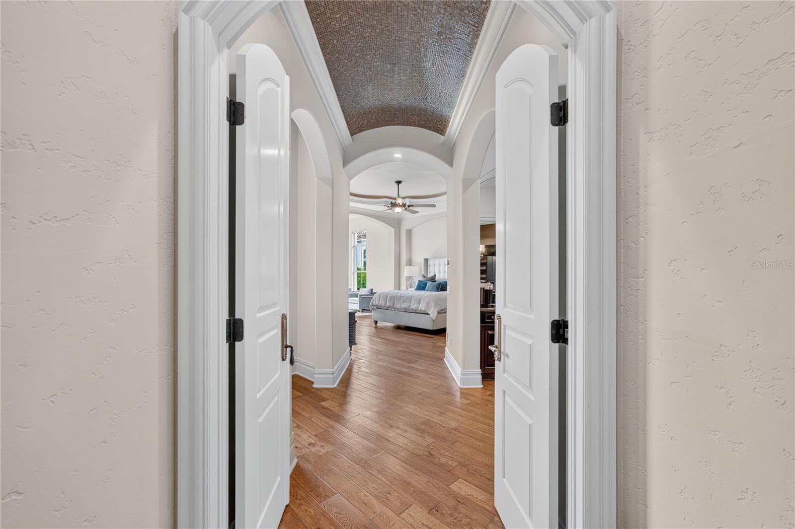 Formal double door entry to primary suite. Notice the intricate barrel mosaic tile ceiling. The left archway leads to the private access to pool terra