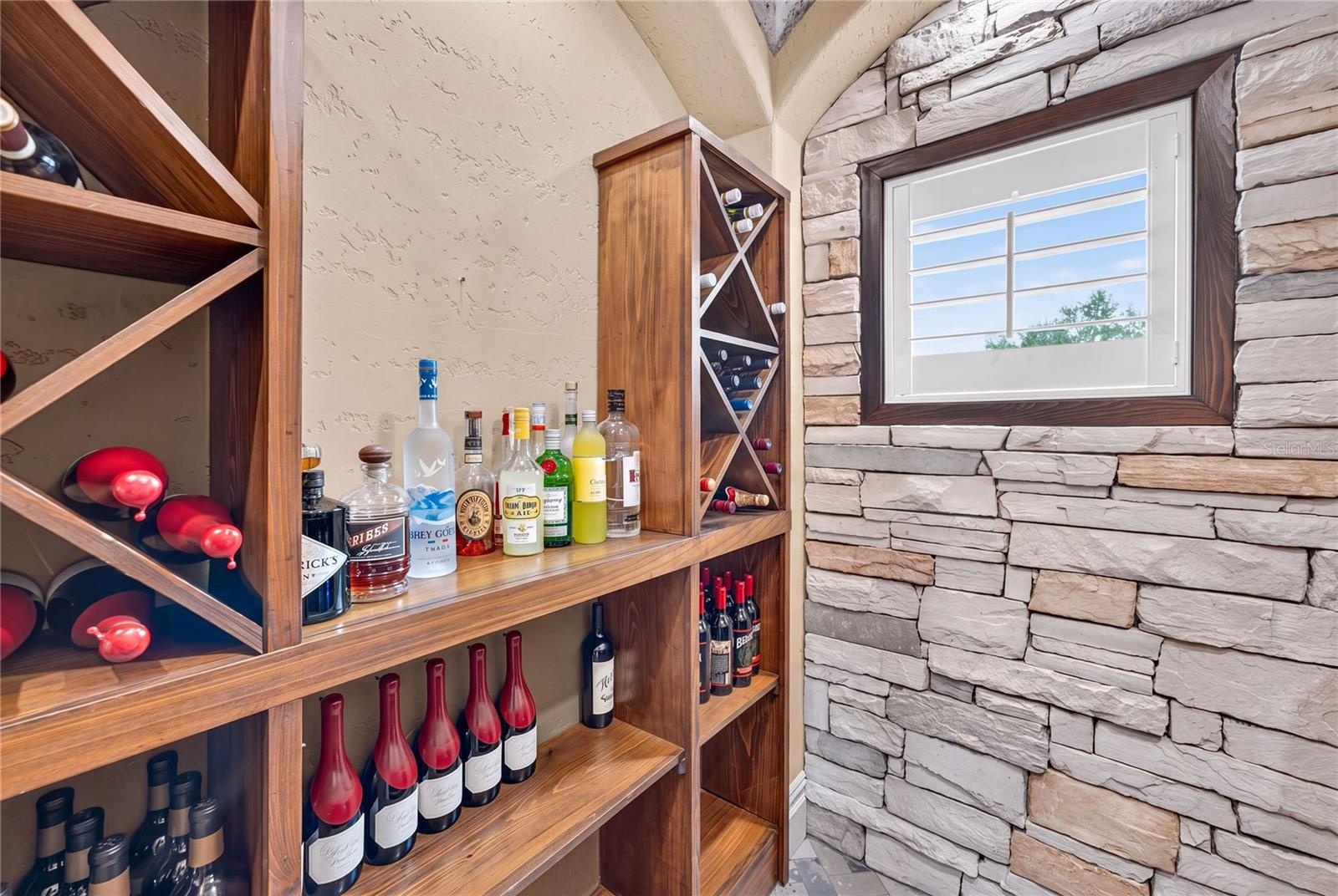 The iron gated Wine Room off the beverage bar offers built in storage and a 45 Bottle BRISA Wine refrigerator.