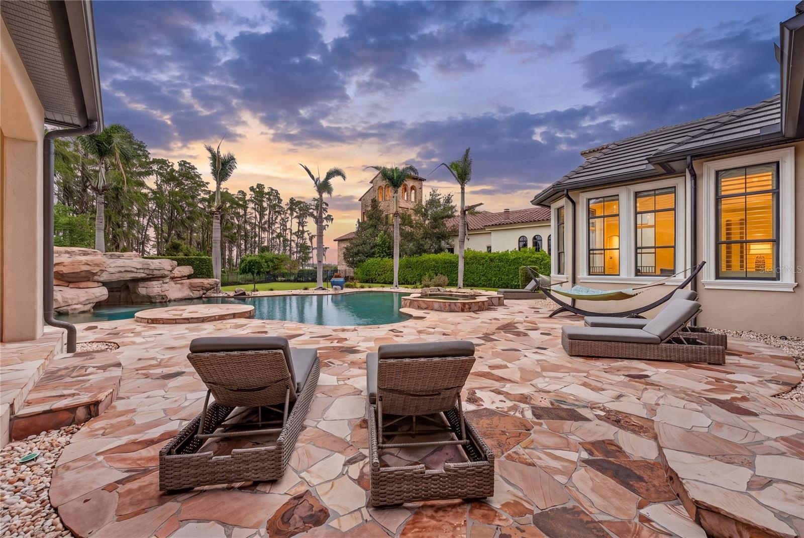 The pool offers a waterfall feature off the rock wall to left  - cascading over the grotto, as well as a heated spa (shown to right back)