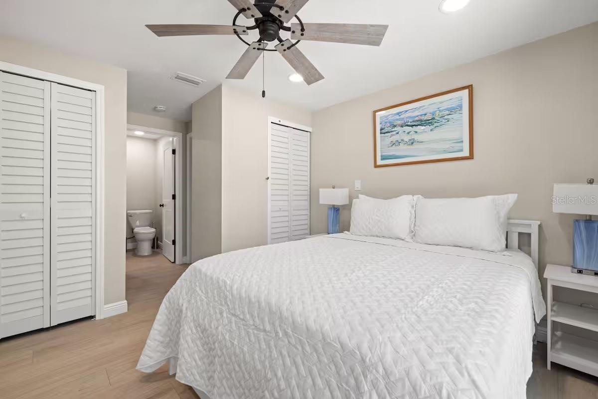 Another view of the primary suite highlights TWO CLOSETS and convenient access to the ensuite bath.