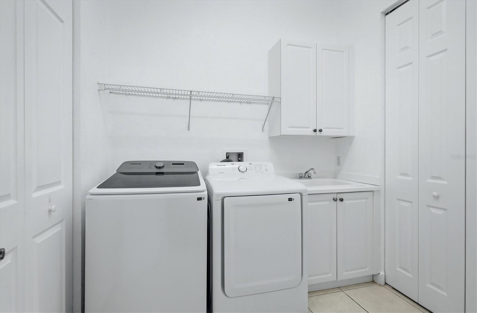 laundry room with cabinets and storage closet