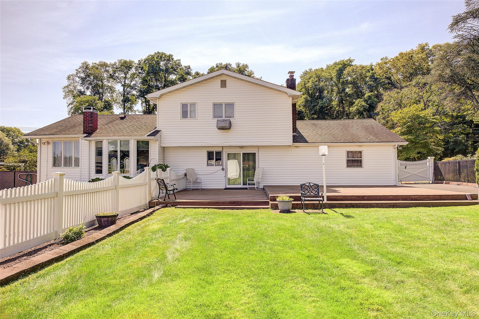 View of the rear of the home. Another manicured lawn.