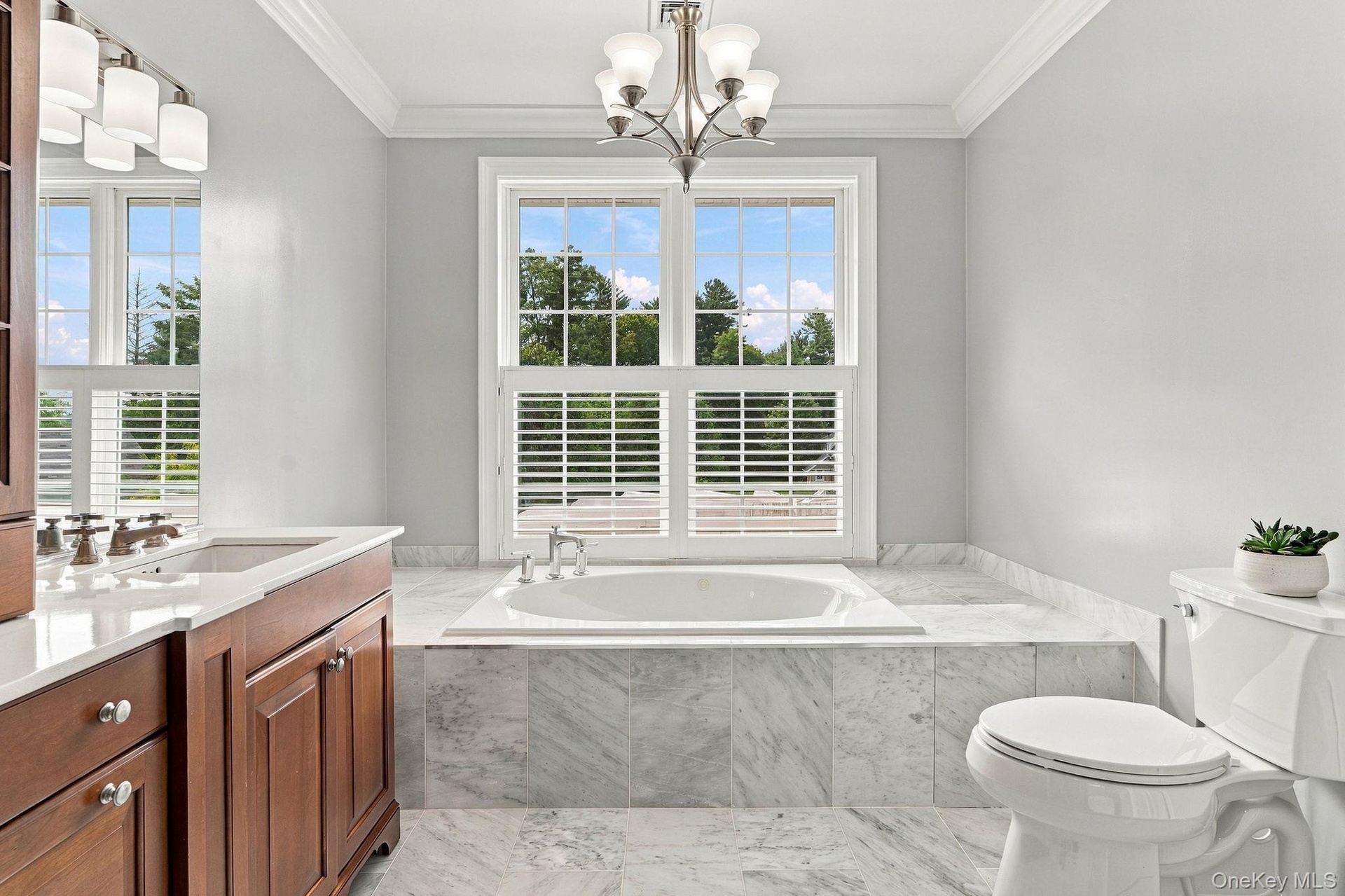 A beautifully appointed ensuite with marble finishes and an elegant soaking tub.