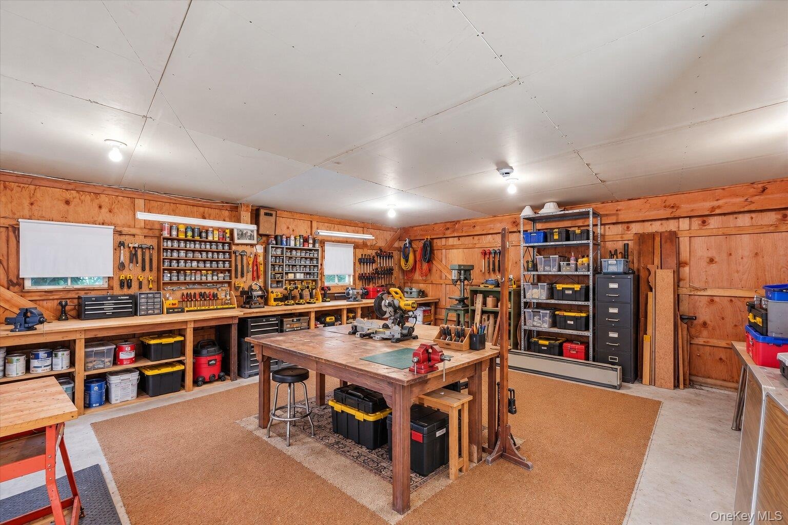 Virtually Staged. Workroom showcasing the extensive shelving, workbenches, and flexible space for projects, hobbies, or storage.