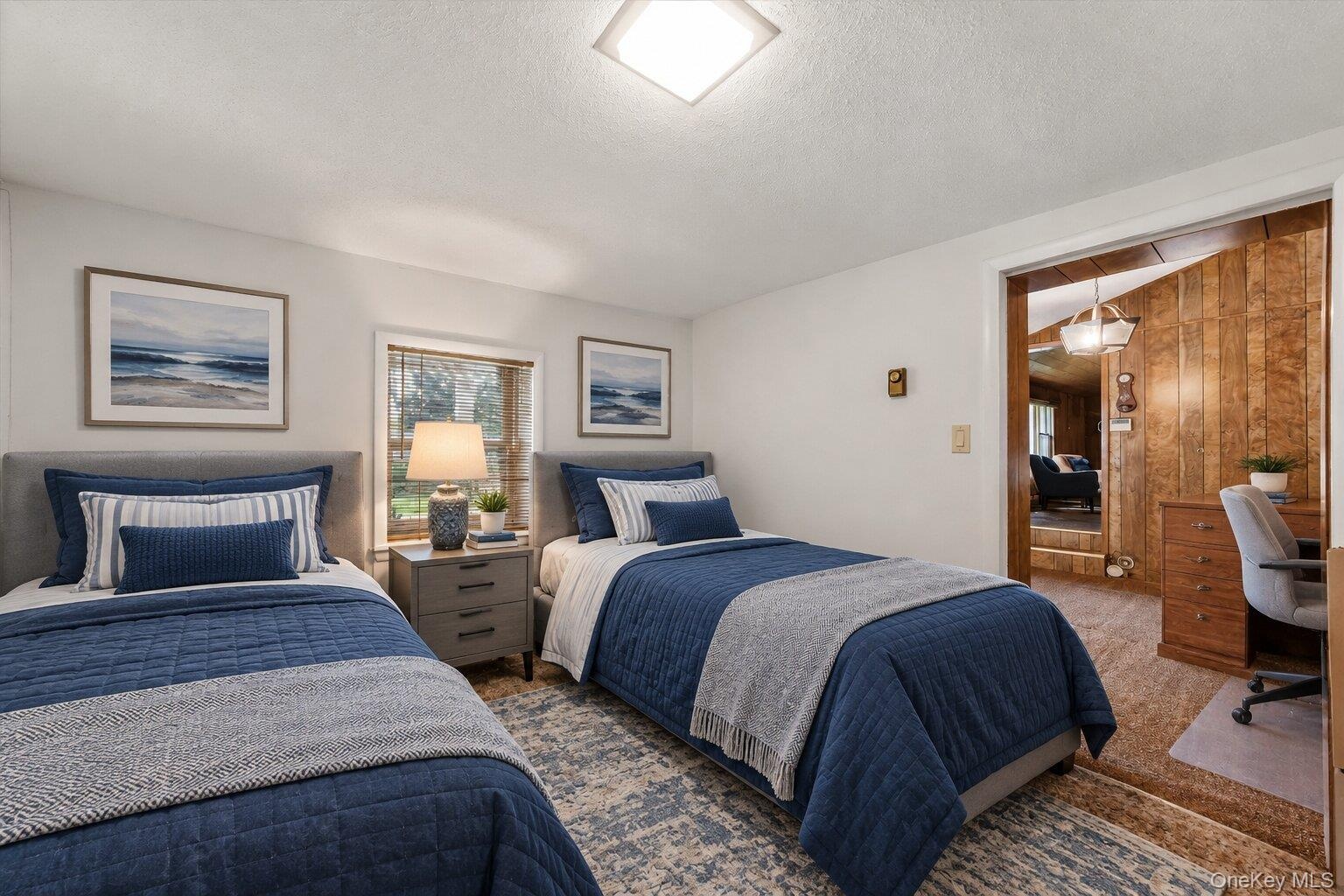 Virtually staged bedroom showcasing a twin-bed layout with space for a dedicated desk or study area.