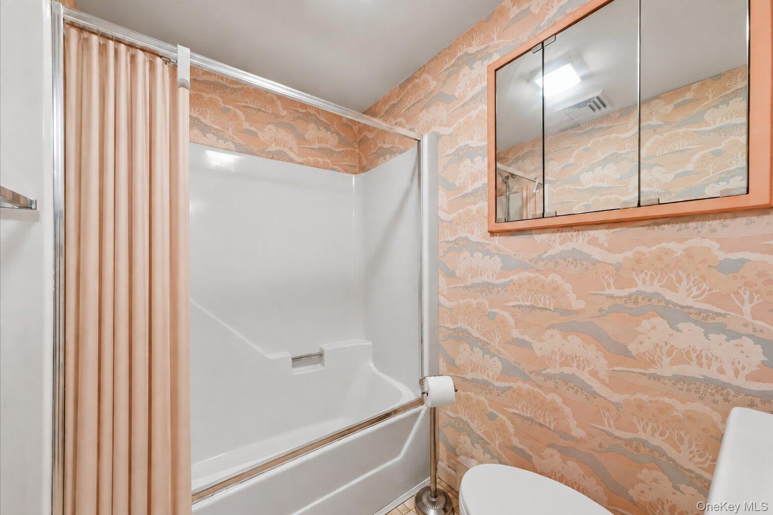 Full bathroom featuring a tub/shower combination, mirrored medicine cabinet, and practical layout.