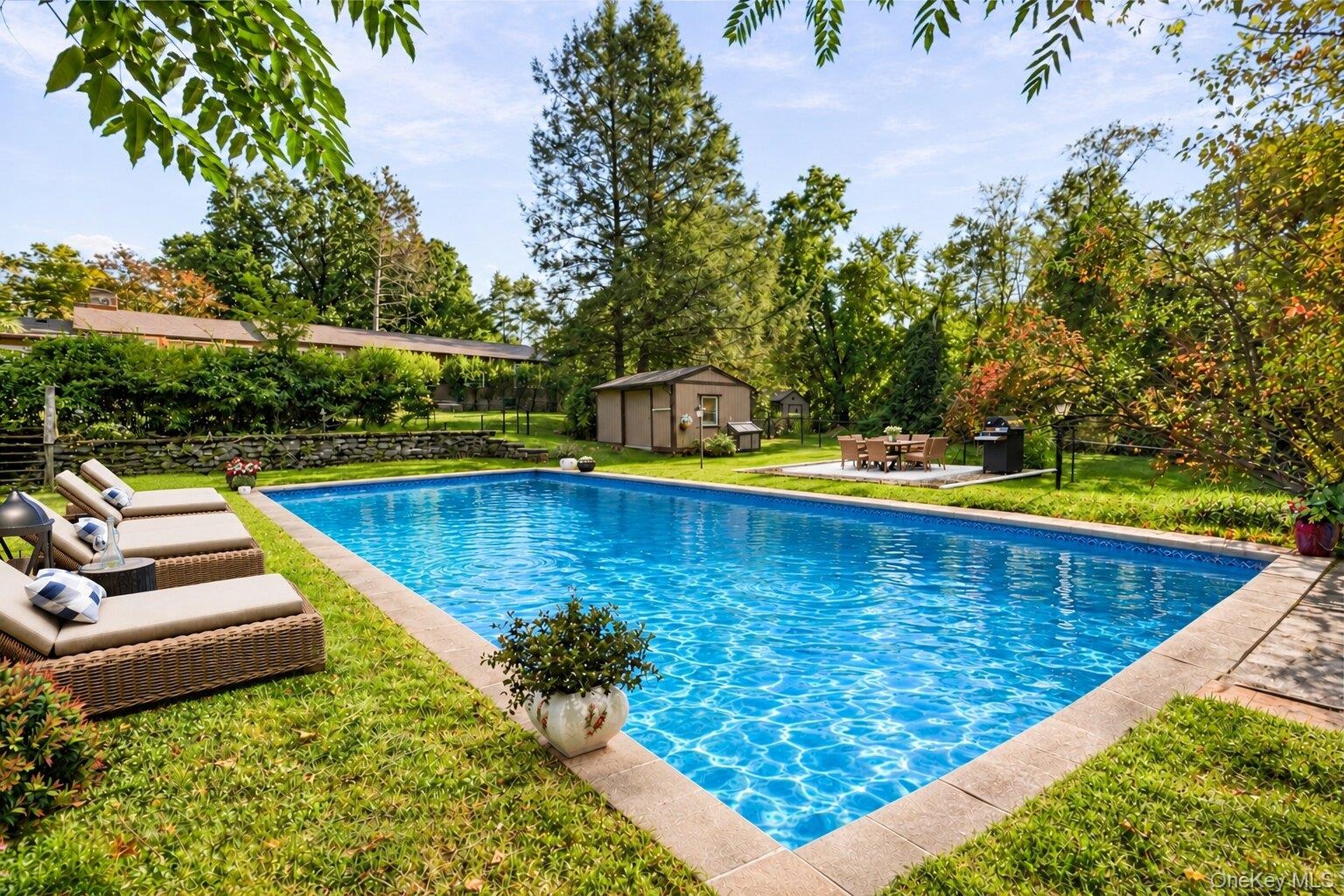 Virtually staged pool area showcasing lounge seating, outdoor dining, and the property’s private landscaped setting