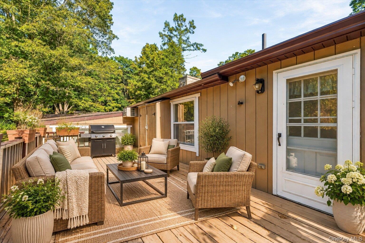 Virtually staged deck showcasing a comfortable outdoor seating area and grilling space.