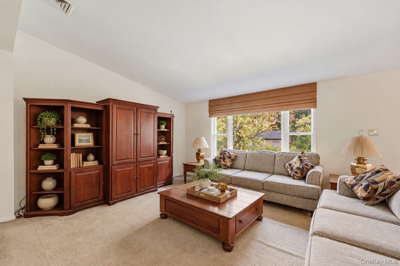 Bright living room with a large window overlooking the surrounding greenery and providing abundant natural light.