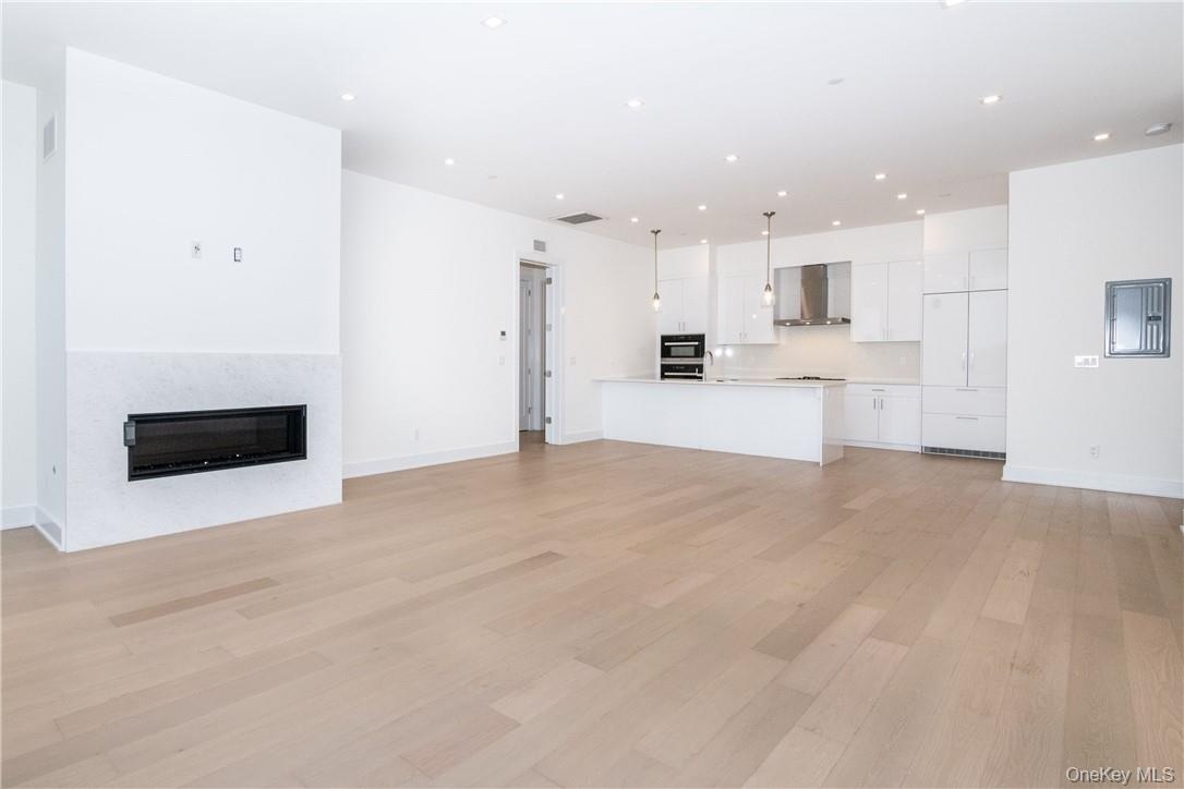 Unfurnished living room with light wood-type flooring and electric panel
