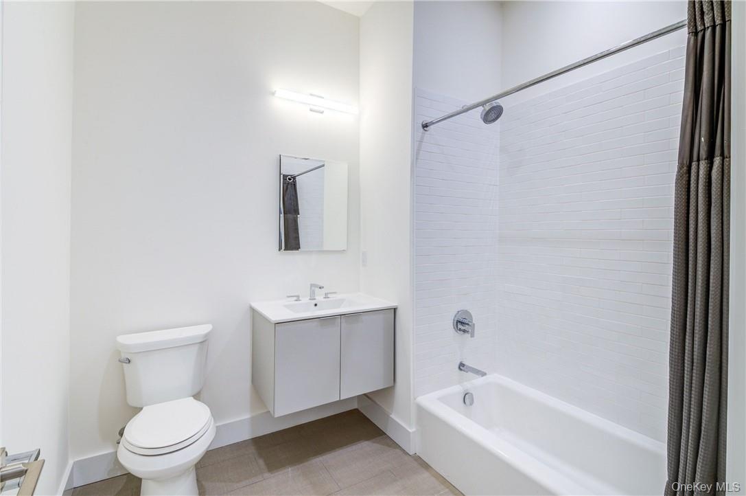 Full bathroom featuring toilet, shower / tub combo, and vanity
