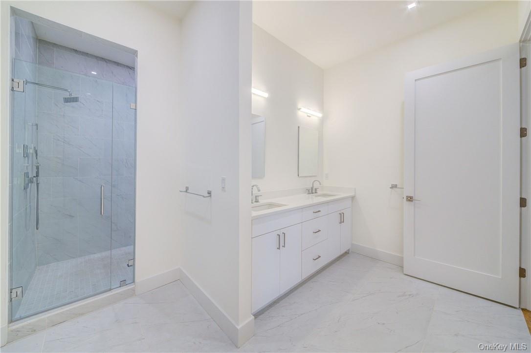 Bathroom with a shower with shower door and vanity