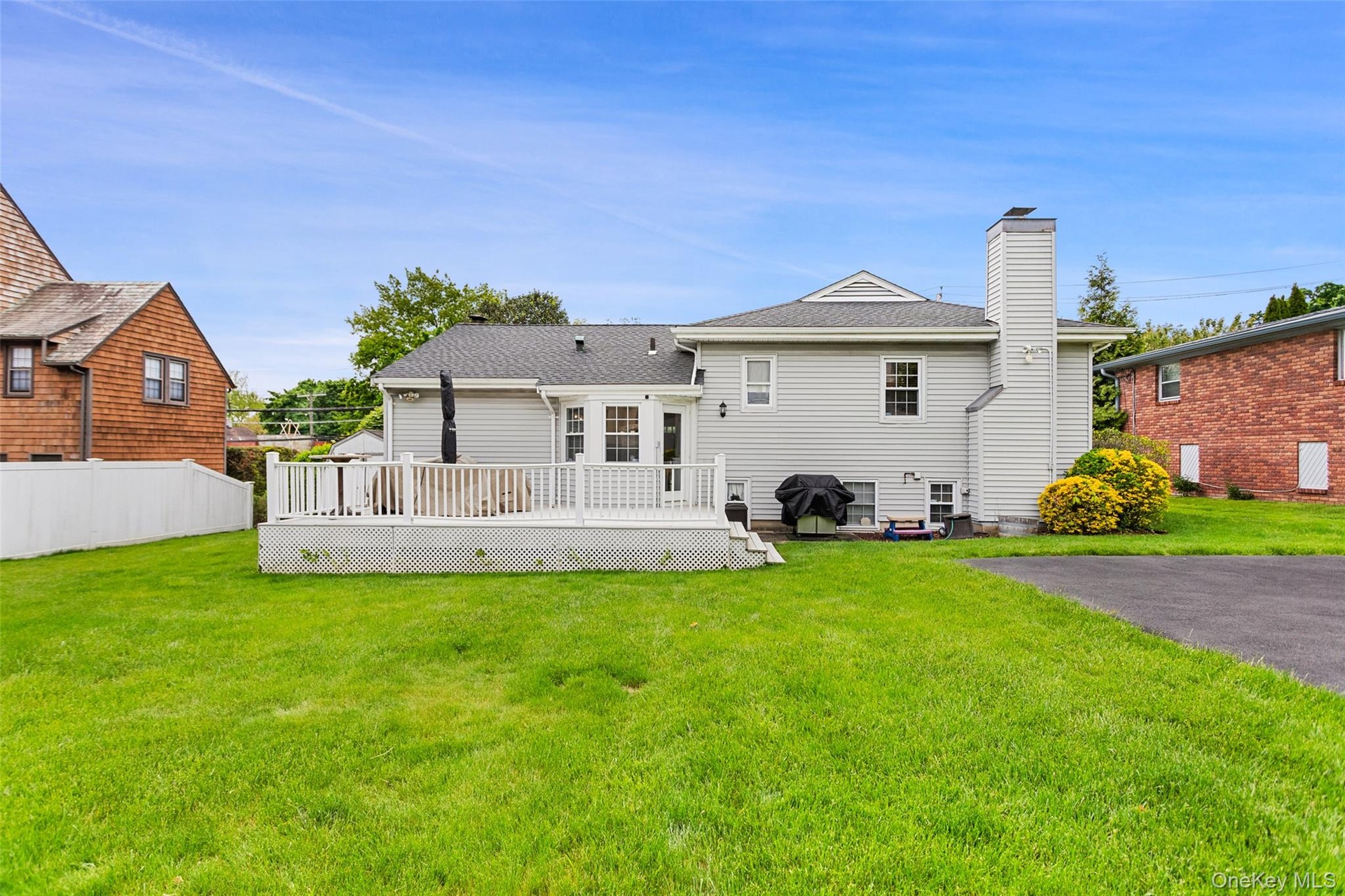 Rear exterior featuring deck and backyard.