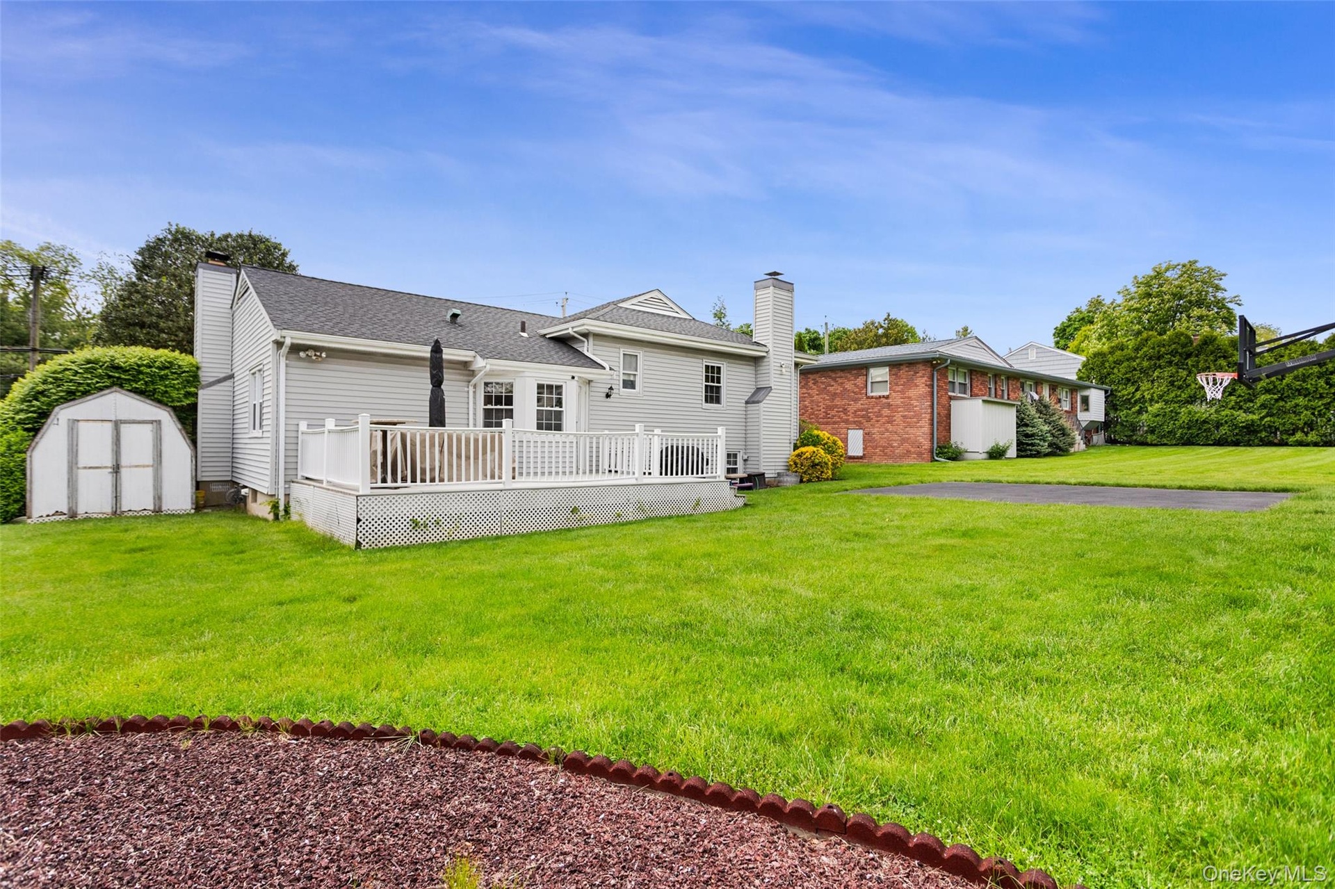 Private backyard with deck and storage shed.