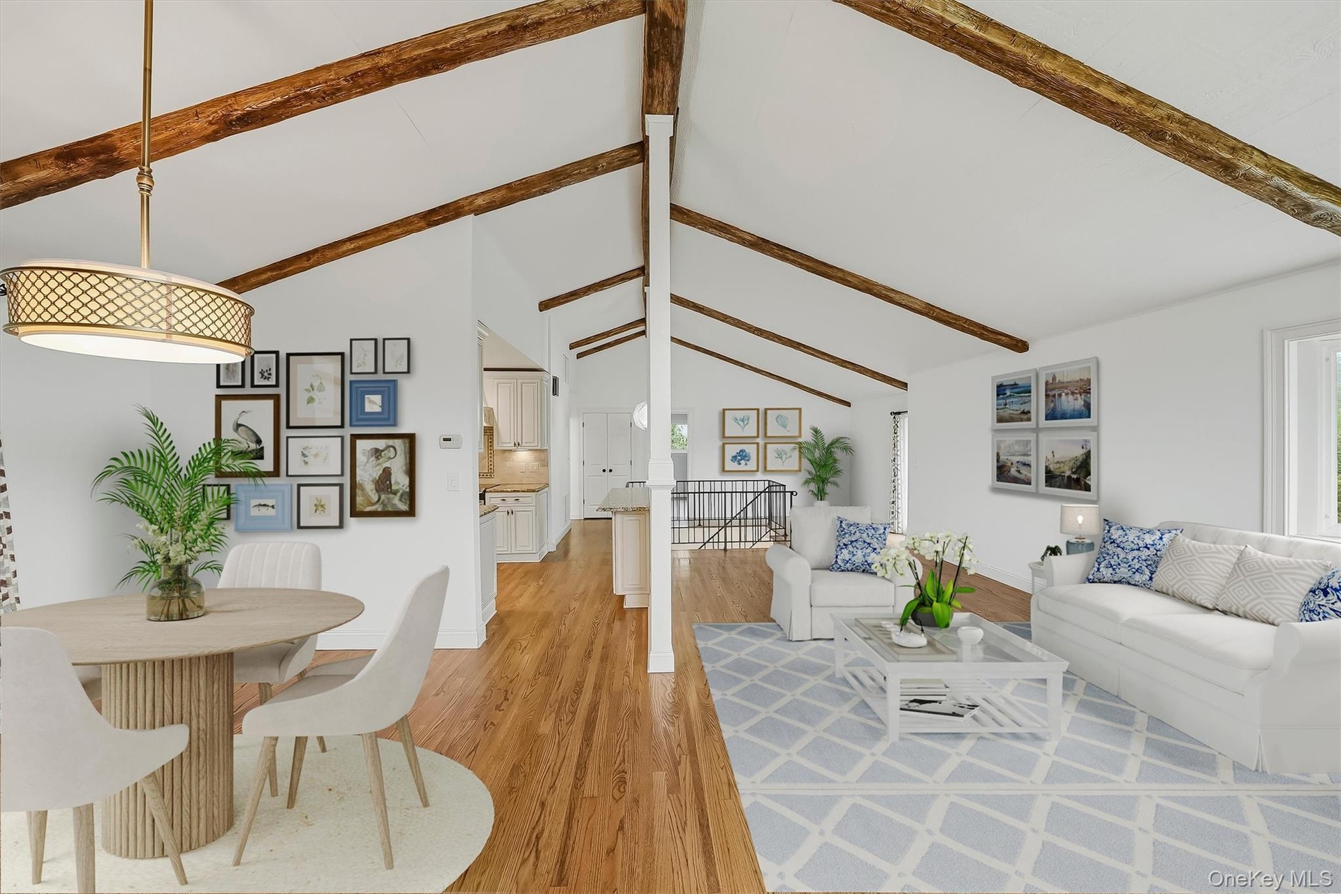 Virtually staged open-plan great room w/ hardwood floors, exposed wood beams, and fresh paint.