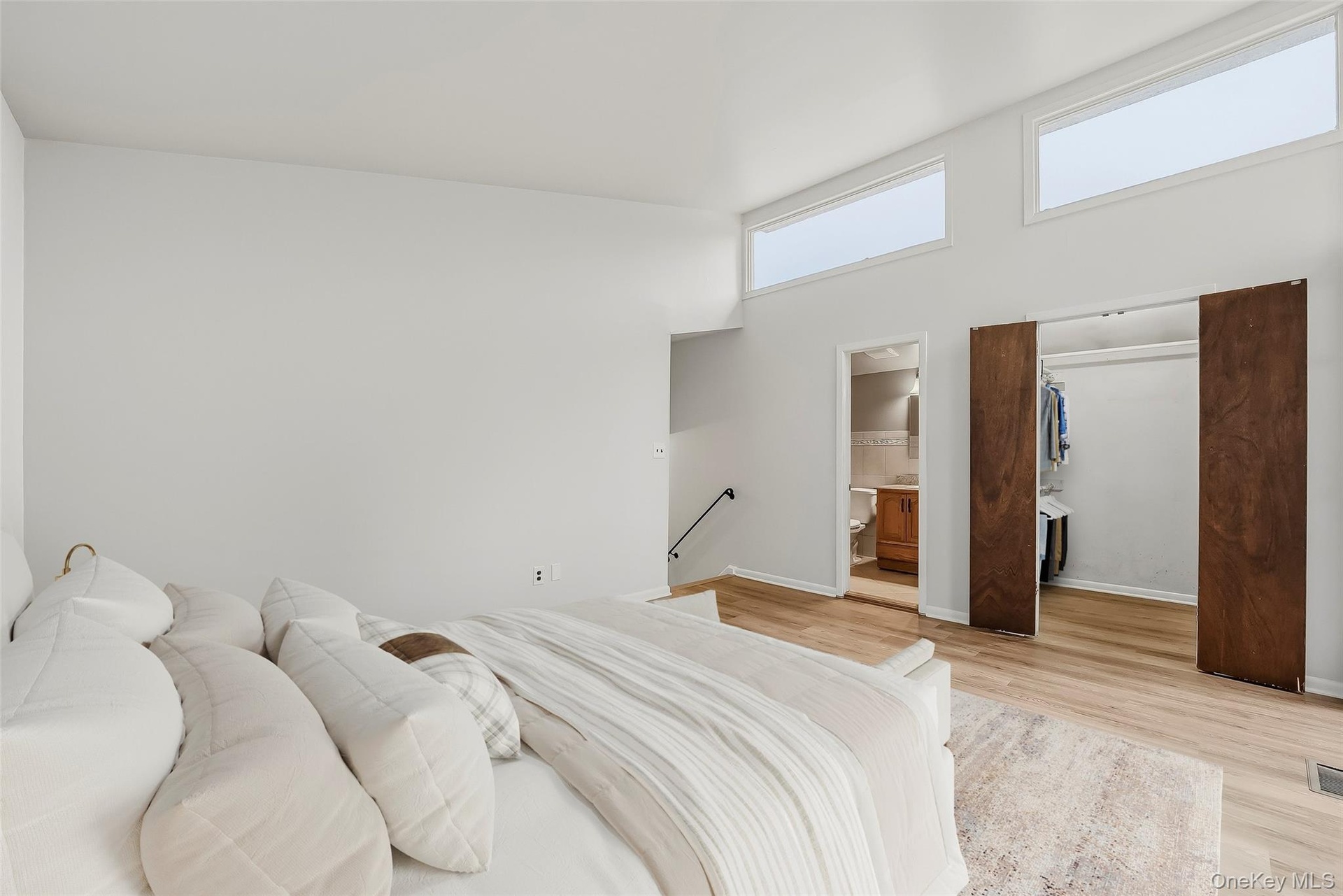 Virtually staged primary bedroom with brand new floors, en-suite bathroom, & walk-in closet.