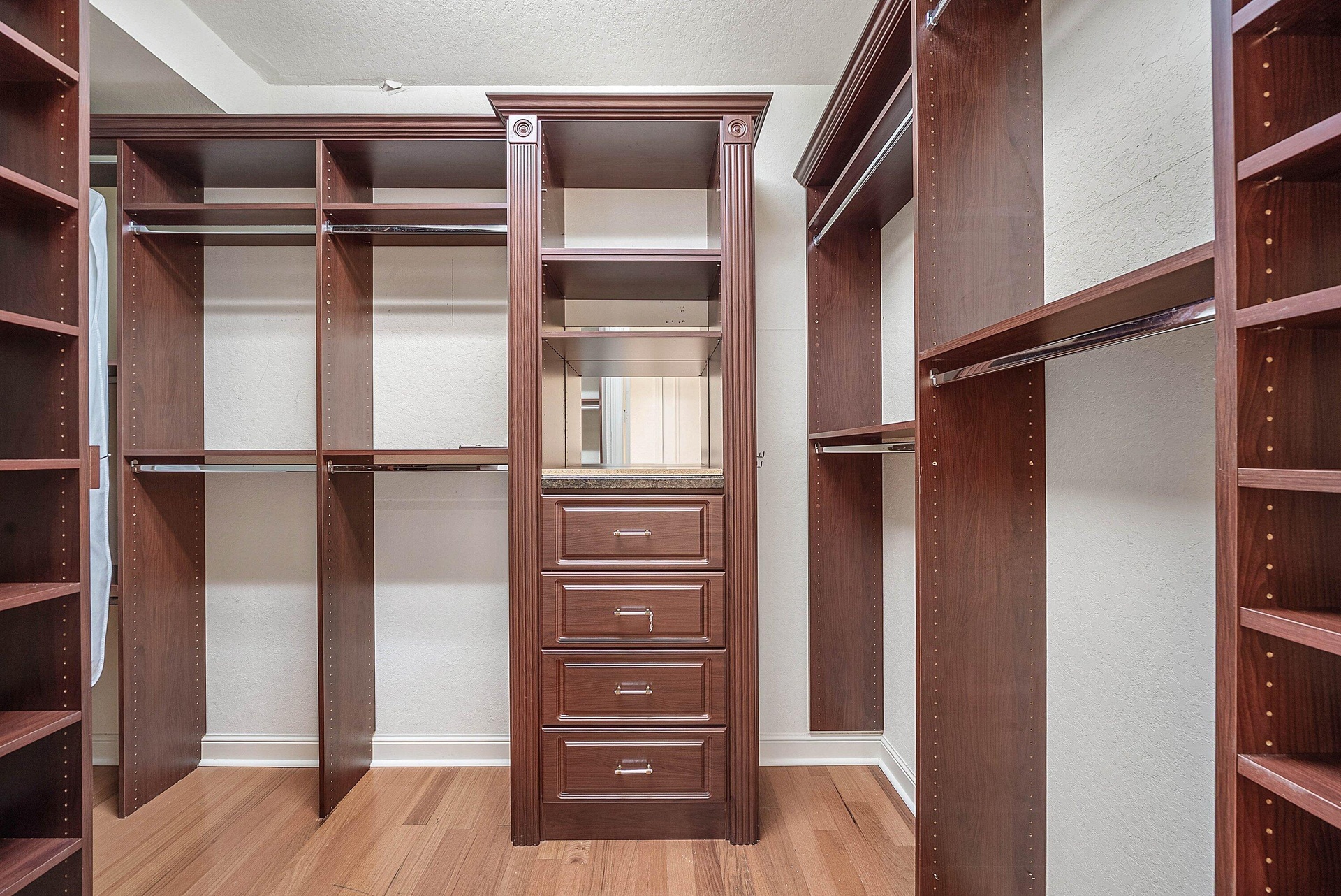 Custom closet system featuring dark wood-finish cabinetry