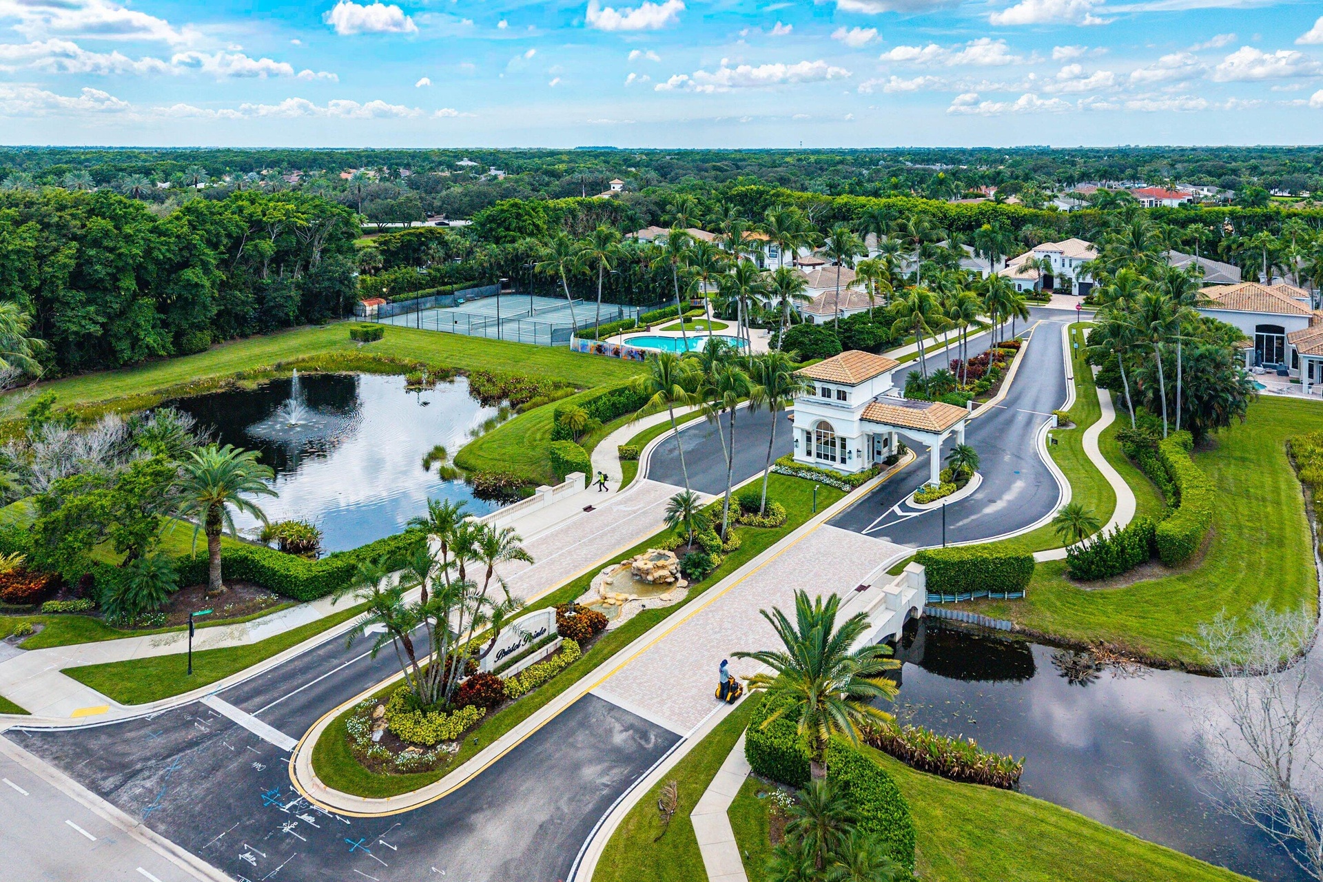 Gated community entrance with a decorative bridge.