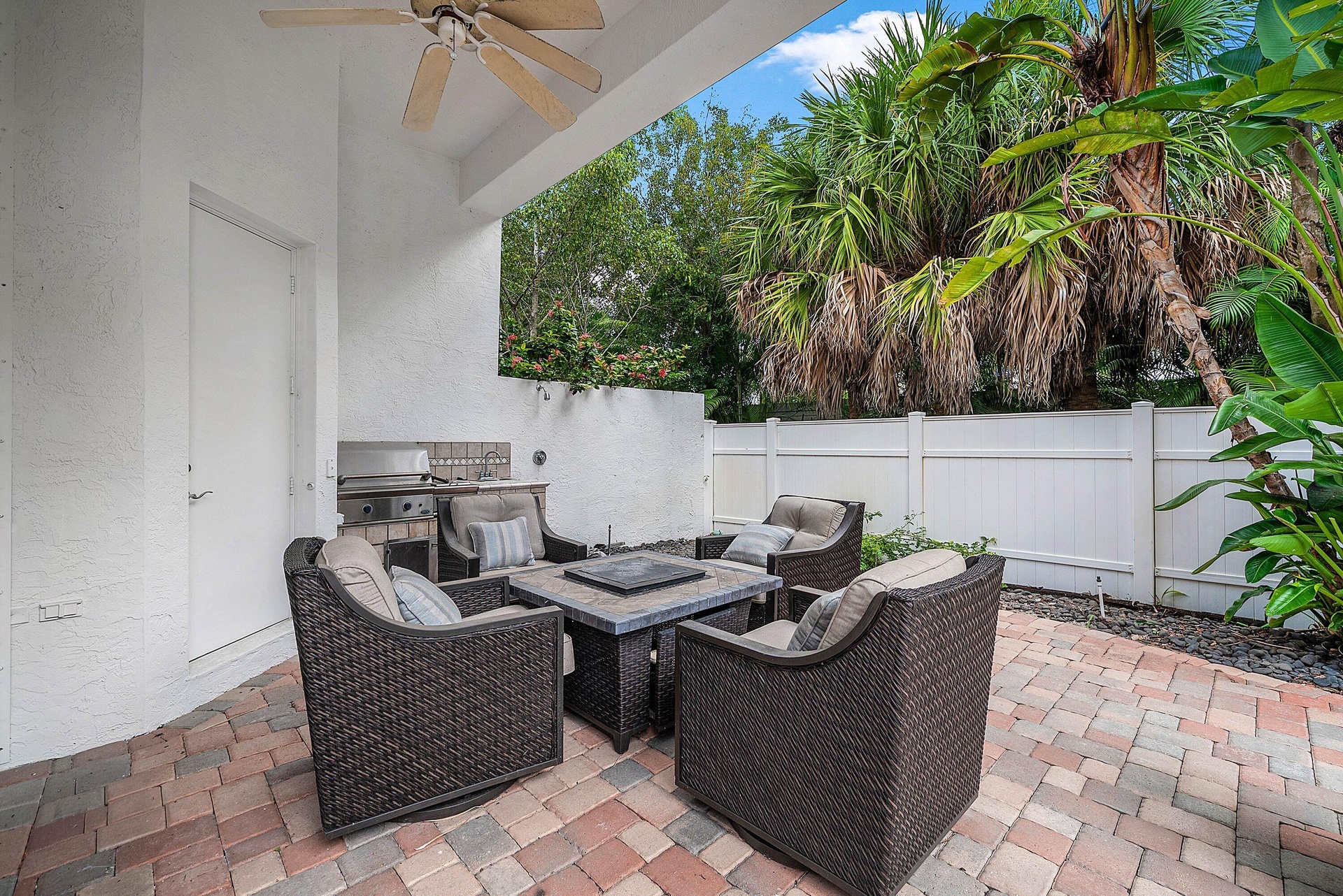 Covered patio featuring a ceiling fan, paver flooring, with a built-in grill, and a privacy fence