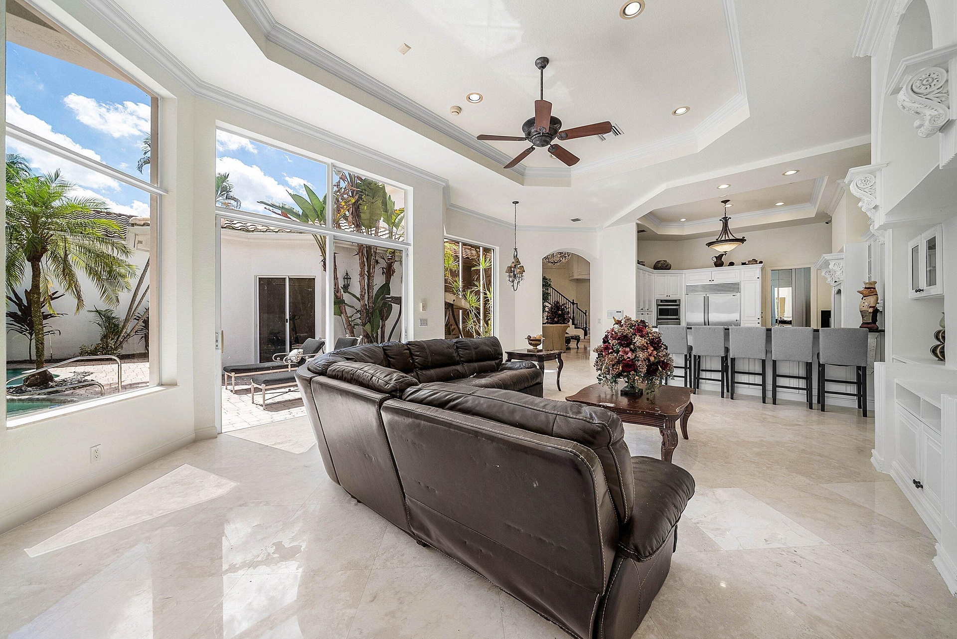 Expansive windows overlooking a private courtyard with lush landscaping and a pool