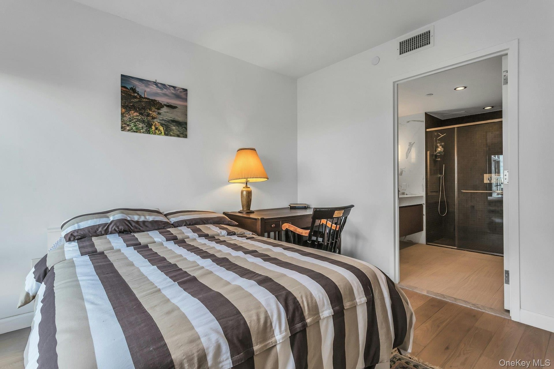 Bedroom featuring wood finished floors and ensuite bath