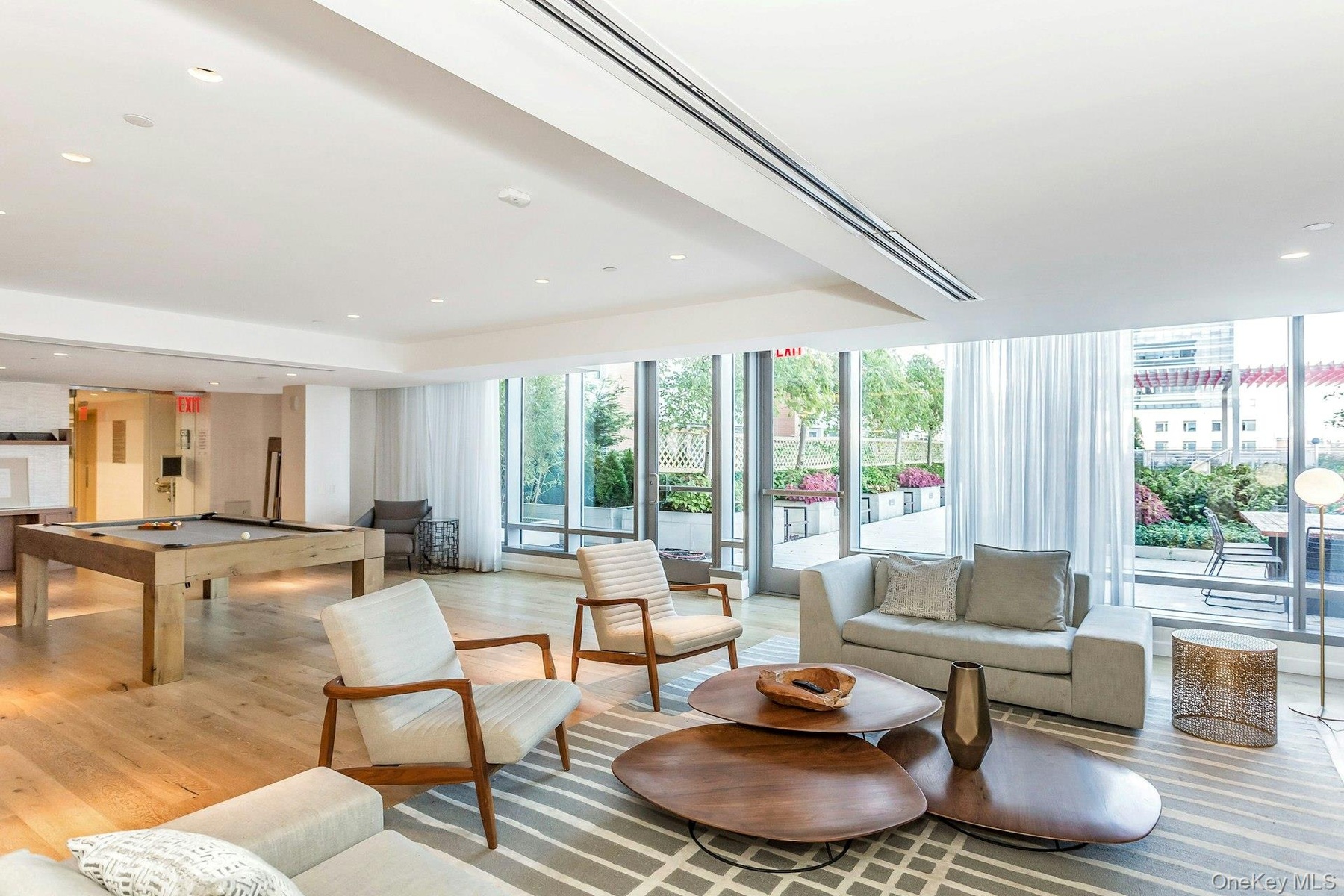 Living room featuring billiards table, floor to ceiling windows, light wood-type flooring, recessed lighting, and a raised ceiling