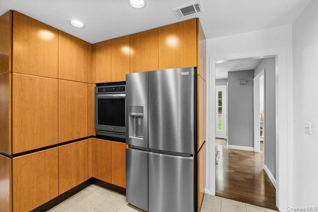 Recessed lighting, stainless steel appliances, built-in oven, full-height cabinetry
