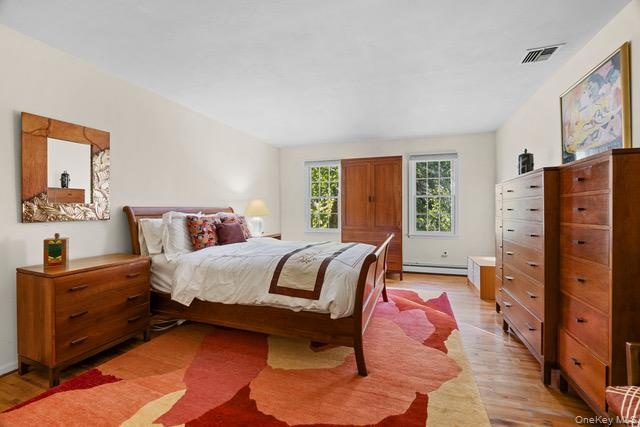 Hardwood flooring throughout, featuring multiple windows, and light-toned wall finishes