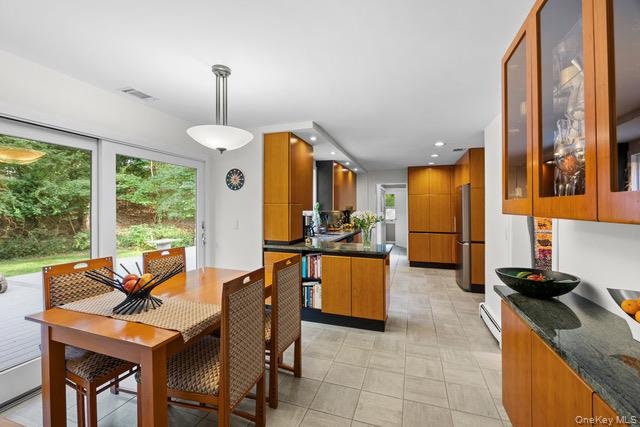 Kitchen and dining area featuring wood-finish cabinetry, and integrated stainless steel appliances