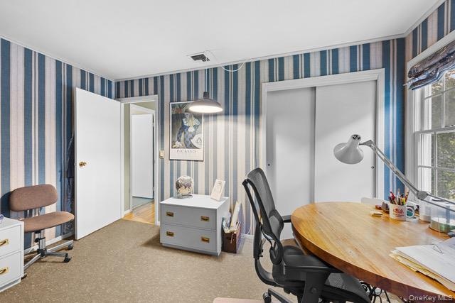 Room with striped wallpaper, a built-in sliding closet, a window with exterior views, and a recessed ceiling light fixture